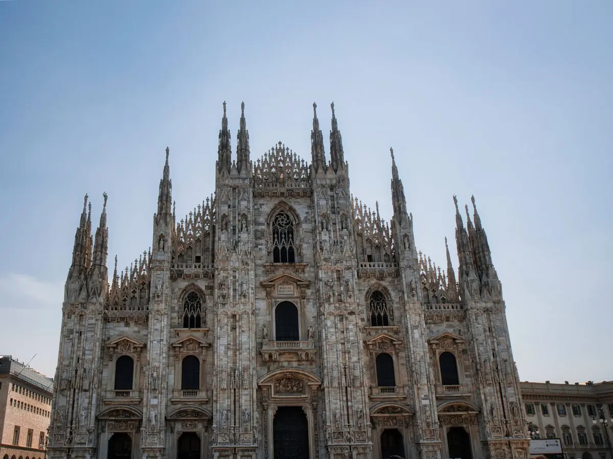 La façade gothique du Duomo de Milan sous un ciel bleu